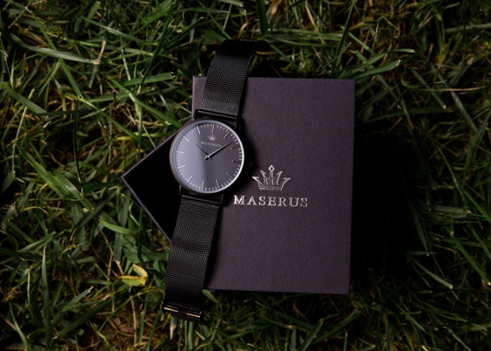Mens all black watch on top of gift box.