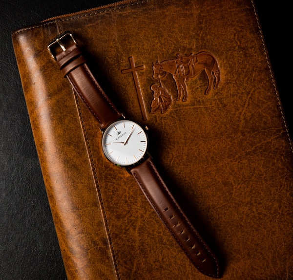 Mens watch next to a Christian cross case.